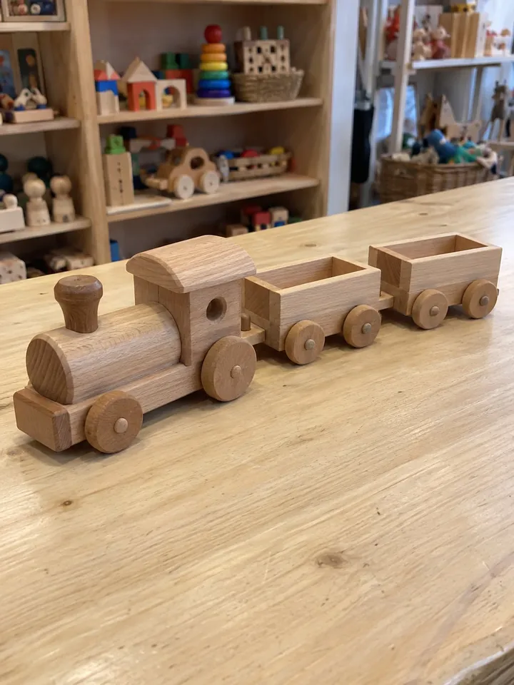 Phone photo from the shop: wooden train with a locomotive and two wagons on the shop counter